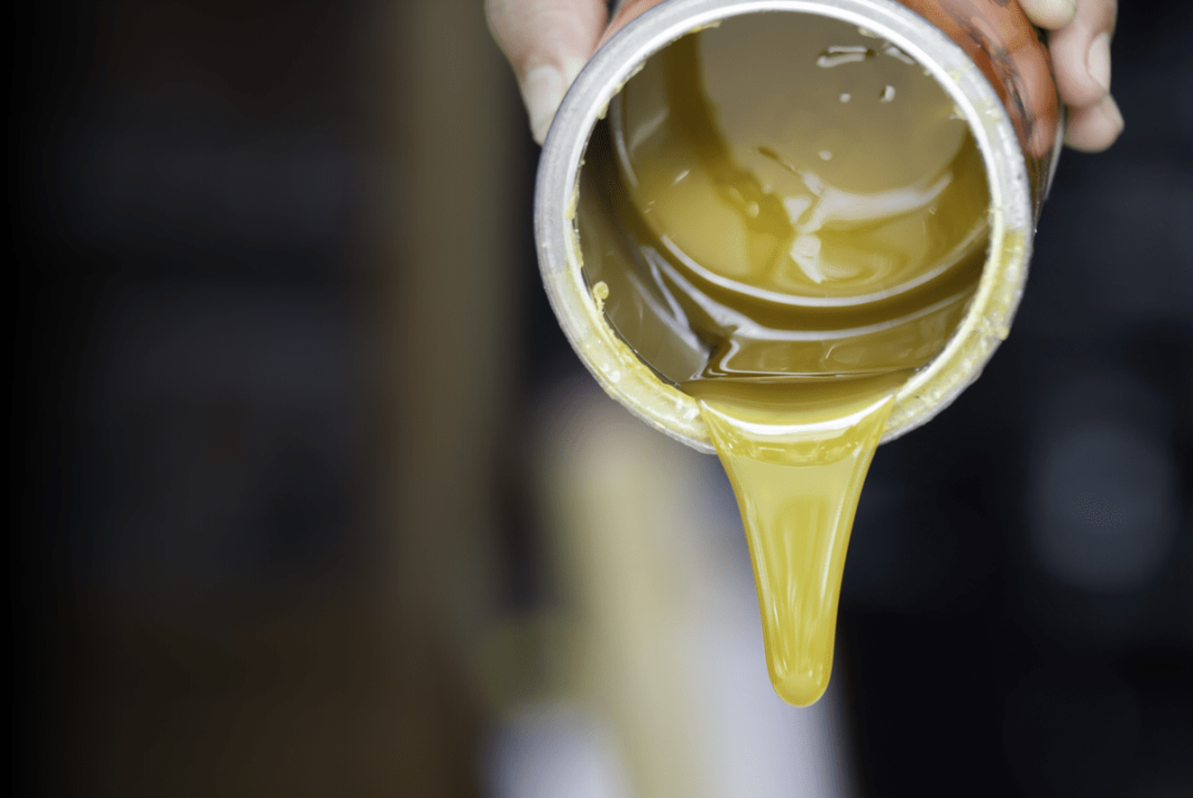 Yellow coating material being poured from a container